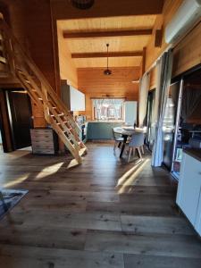 a living room with a wooden floor and a staircase at domek przy Jodłowej in Niesulice