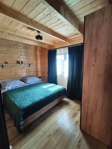 a bedroom with a bed in a log cabin at domek przy Jodłowej in Niesulice