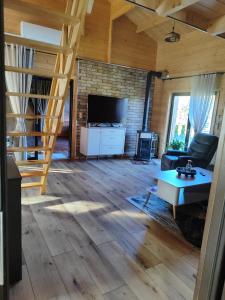 a living room with wooden floors and a staircase at domek przy Jodłowej in Niesulice