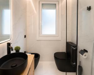 a bathroom with a black sink and a window at Holibai Antia Mare Centro de Baiona y mar in Baiona +12 photos