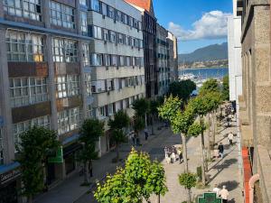 a city street with buildings and people walking on the sidewalk at Holibai Antia Mare Centro de Baiona y mar in Baiona