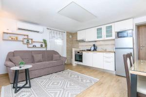 a living room with a couch and a kitchen at House Romance for two in Zagvozd