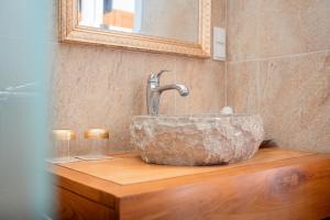 a bathroom with a stone sink on a wooden counter at Lagoa Beach House B&B - Breakfast included in Serra do Bouro +39 photos