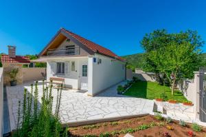 a small house with a white garage at House Romance for two in Zagvozd