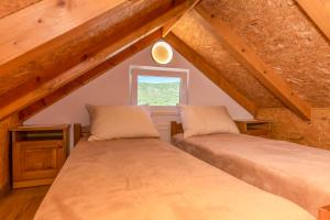 two beds in a attic room with a window at House Romance for two in Zagvozd +31 photos