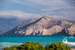 a view of the ocean with a mountain in the background at Mandy Apartman in Baška