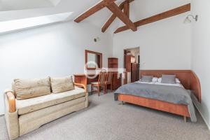 a bedroom with a bed and a couch and a table at Letnia Przystań Rowy in Rowy