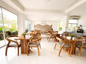 a restaurant with wooden tables and chairs and windows at Eco hotel oasis del mar in Cartagena de Indias