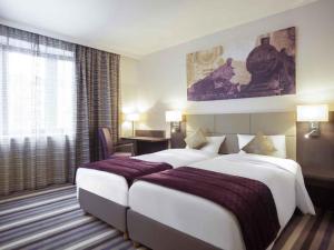 a hotel room with two beds and a window at Mercure Hotel Brussels Centre Midi in Brussels +100 photos