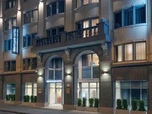 a large building with windows and plants in front of it at Mercure Hotel Brussels Centre Midi in Brussels