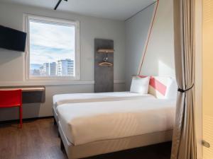 a hotel room with a bed and a window at ibis budget Genève Petit-Lancy in Geneva +44 photos