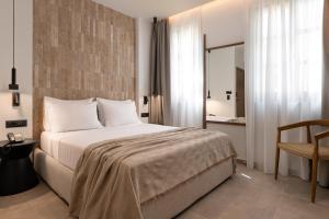 a hotel room with a large bed and a chair at Karavel Suites - Old Town in Rhodes Town +33 photos