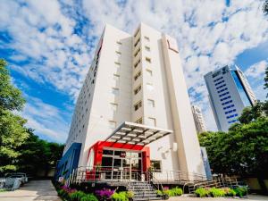 a tall white building with a red door at ibis Asuncion in Asunción