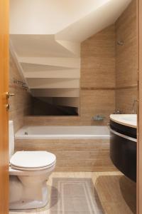 a bathroom with a toilet and a sink and a tub at Maisonette ELINA in Corfu +20 photos