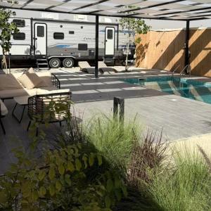 an rv is parked next to a patio with a pool at cozy rv in Falaj al Mu‘allá