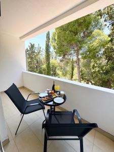 a balcony with a table and chairs and a window at Illyrian Resort in Milna