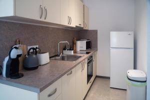a kitchen with a sink and a white refrigerator at Kaba Home - Mountain Villa with Sauna in Stoykite +26 photos