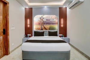 a bedroom with a bed with a painting on the wall at Hotel O Maruti Hotel in Indirapuram