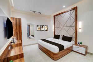 a bedroom with a large bed and a television at Hotel O Maruti Hotel in Indirapuram