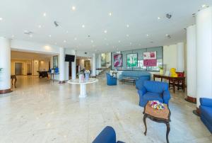a lobby with blue chairs and a table at Hotel Sakura, Sure Hotel Collection by Best Western in Torre del Greco