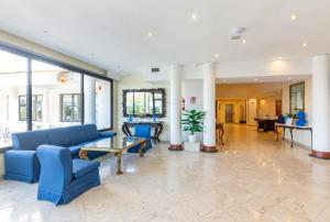 a lobby with a blue couch and a table at Hotel Sakura, Sure Hotel Collection by Best Western in Torre del Greco
