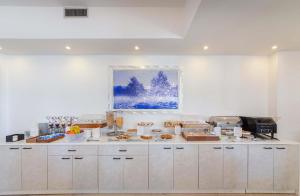 a kitchen with a counter with pastries on it at Hotel Sakura, Sure Hotel Collection by Best Western in Torre del Greco