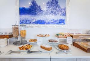a buffet with different types of pastries and desserts at Hotel Sakura, Sure Hotel Collection by Best Western in Torre del Greco