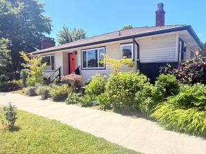 a house with a red door and some plants at The Orange Door Bungalow- 2-BR w private yard, walkable to cafes & restaurants, 10 min to DT in Vancouver