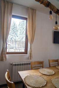 a dining room with a table and a window at Kaba Home - Mountain Villa with Sauna in Stoykite