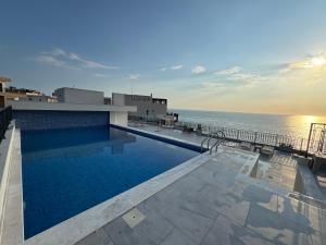 a swimming pool on the roof of a building overlooking the ocean at Prestige Lux Apartment in Bijela Glavica