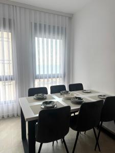 a dining room with a table with chairs and windows at Prestige Lux Apartment in Bijela Glavica +39 photos