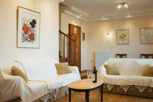 a living room with two white couches and a table at Maisonette ELINA in Corfu