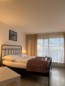 a bedroom with a bed and a large window at Harderkulm in Interlaken
