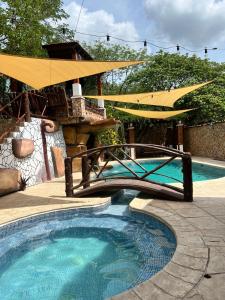 a swimming pool with a bridge and an umbrella at Hotel y Restaurante Donde Pilo in Santa Rita +8 photos