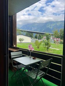 a table and chairs on a balcony with a view at Harderkulm in Interlaken