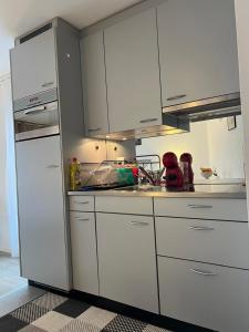 a kitchen with white cabinets and a sink at Harderkulm in Interlaken