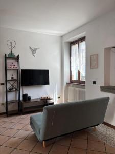 a living room with a couch and a flat screen tv at Casa Chiara in Mandello del Lario