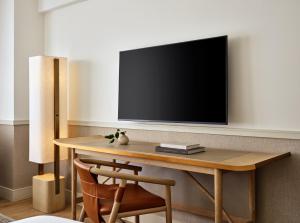 a wooden table with a television on a wall at Kimpton Ashbel New York Park Avenue by IHG in New York +55 photos