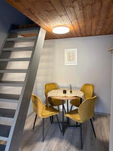 a dining room with a table and yellow chairs at Samu Tanya in Gyula