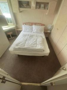 a bed with white sheets and pillows in a room at Herons mead 12 in Addlethorpe