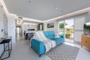 a living room with a blue couch and a kitchen at Casa Victoria · Golf, Sun and Sea Breeze. Mojácar in Mojácar