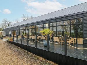 a black house with windows and a patio at Badger's Burrow in Oakham
