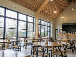 a restaurant with tables and chairs and large windows at Badger's Burrow in Oakham