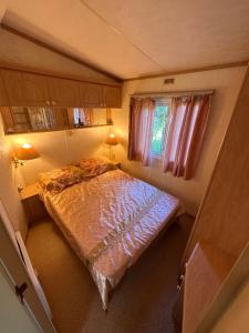 a small bedroom with a bed in a tiny house at Английский домик in Lapmežciems