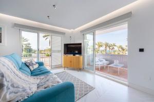 a living room with a blue couch and a television at Casa Victoria · Golf, Sun and Sea Breeze. Mojácar in Mojácar