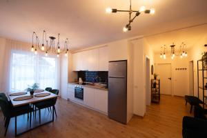 a kitchen and dining room with a table and a dining room at Izium Central Residence in Baia Mare