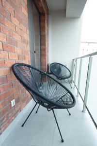 a black bench sitting on a balcony next to a brick wall at Izium Central Residence in Baia Mare