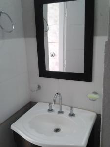 a bathroom with a white sink and a mirror at Punta Gesell in Villa Gesell