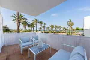 a balcony with chairs and a table and palm trees at Casa Victoria · Golf, Sun and Sea Breeze. Mojácar in Mojácar