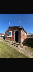 a brick house with a door in a yard at Saddlebrook 156 in Leysdown-on-Sea
